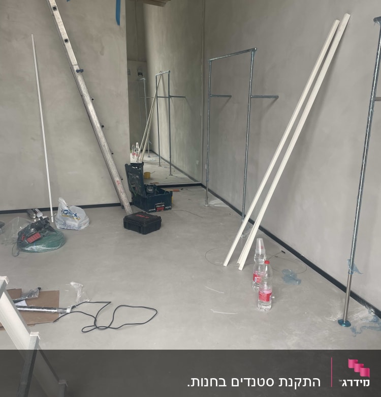 סולם, כלי עבודה, צינורות מתכת, חוט חשמל על רצפה